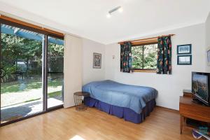 a bedroom with a bed and a flat screen tv at Inlet Views at 20 The Loop in Narooma