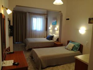 a hotel room with two beds and a window at Maria Studios in Patitiri