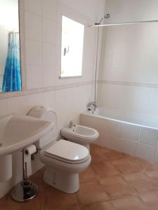 ein Badezimmer mit einem WC, einem Waschbecken und einer Badewanne in der Unterkunft Montes Galegos in Aljezur