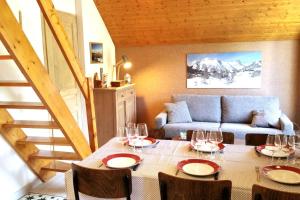 a dining room with a table and a couch at FORSYTHIA LE MAS DU PEYRON in Saint-Chaffrey