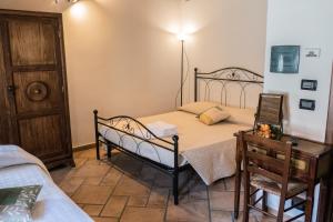 ein Schlafzimmer mit einem Bett, einem Tisch und einem Stuhl in der Unterkunft B&B I tre gadan in Volpiano