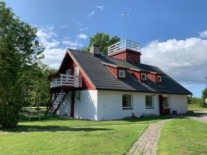 a red and white house with a staircase on top at Tooraku Turismitalu in Pusku