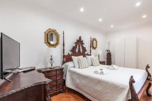 sypialnia z łóżkiem, komodą i lustrem w obiekcie CASA DE LA LUZ -Elegante Casco Antiguo 5-Hab w Sewilli