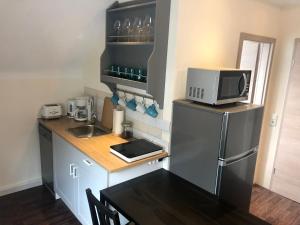 a small kitchen with a refrigerator and a microwave at Westfalische Apartments in Lennestadt