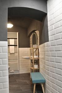 a bathroom with white tiles and a blue chair at Pension Wielsch in Görlitz