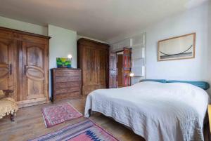 Schlafzimmer mit einem weißen Bett und Holzschränken in der Unterkunft séjour Haut Marais in Paris