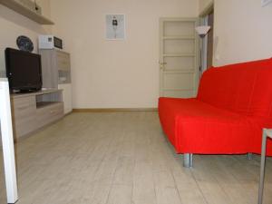 フィレンツェにあるAppartamento con terrazzaのリビングルーム(赤いソファ、テレビ付)