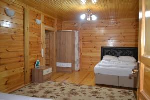 a bedroom with a bed in a wooden cabin at Ozturk Apart in Uzungöl