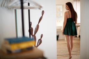 a woman in a green dress standing in a room at Musae Relais & SPA in Polignano a Mare