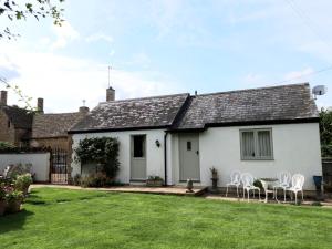 Casa blanca con sillas y patio en Wayside House B&B, en Whichford