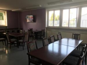 a dining room with tables and chairs and windows at Gästehaus Sandra in Sulzbach-Rosenberg