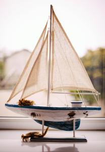 a toy sailboat sitting on a window sill at Little Haven in Seahouses