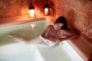 a woman is sitting in a hot tub at Musae Relais & SPA in Polignano a Mare