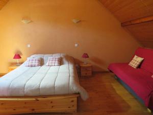 a bedroom with a white bed and a red couch at Les chambres du cru in Jongieux