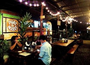 a group of people sitting at tables in a restaurant at Domi Cabin in Dominical