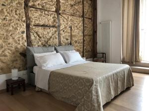 1 dormitorio con 1 cama grande y pared de piedra en Palazzo Pizzo Dependance delle Grazie, en Pizzo