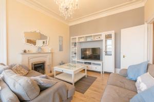 a living room with a couch and a tv and a fireplace at Arran View in Prestwick