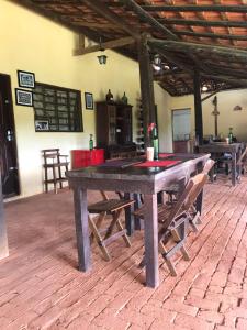 a large wooden table with chairs in a room at Rancho Cavalo Mania in São Roque