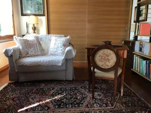 - un salon avec une chaise et une étagère dans l'établissement Maison Claudià al Lido di Venezia, sur le Lido de Venise