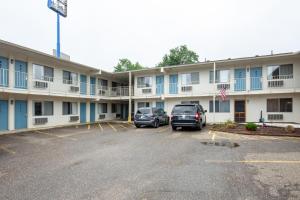 a hotel with two cars parked in a parking lot at Days Inn by Wyndham New Philadelphia in New Philadelphia