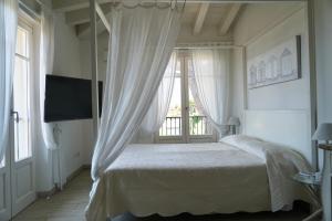 a white bedroom with a bed and a window at Hotel La Primula in Forte dei Marmi