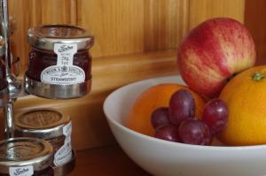 un tazón de fruta en una barra con un tazón de manzanas y uvas en Brook House ― Free on-site car park en Windermere