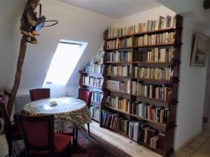 a room with a book shelf filled with books at Les chambres des Demoiselles in Beauval