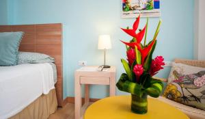 
a vase filled with flowers on top of a bed at Posada La Fe by BespokeColombia in Cartagena de Indias

