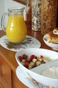 uma mesa com uma taça de fruta e um jarro de sumo de laranja em Brook House ― Free on-site car park em Windermere