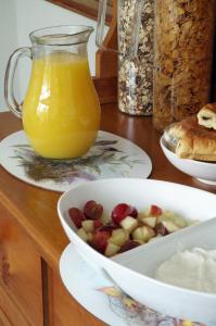 a table with a bowl of fruit and a jug of orange juice at Brook House ― Free on-site car park in Windermere
