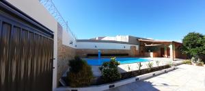 a house with a swimming pool next to a building at Deck com suíte/piscina/garagem. Próx. UFCA/Unileão in Juazeiro do Norte