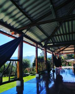 een veranda met een hangmat en uitzicht op de bergen bij Hostal Taita Cristobal in Isinliví
