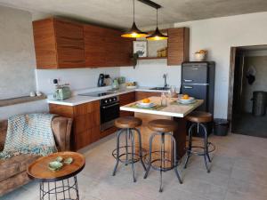 a kitchen with a counter and bar stools in a kitchen at The Loft Gozo in Xagħra
