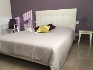 1 dormitorio con 1 cama blanca grande con almohadas amarillas en La Maison de Caillette, en Camaret-sur-Aigues