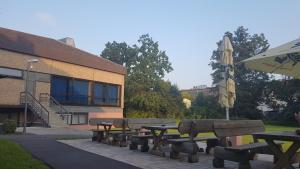 een groep picknicktafels en een parasol naast een gebouw bij Gästehaus Sandra in Sulzbach-Rosenberg +24 foto's