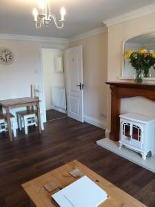 a living room with a fireplace and a table at The Tree House in Durham