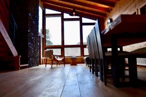 a room with a large window and a wooden floor at Chalet Ciprés in Las Trancas