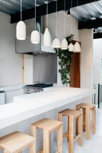 a kitchen with a white counter and wooden stools at Casa Pancha in Mexico City