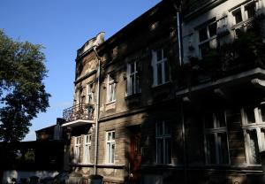 un antiguo edificio de piedra con ventanas blancas en una calle en Apartament Parkowa, en Przemyśl