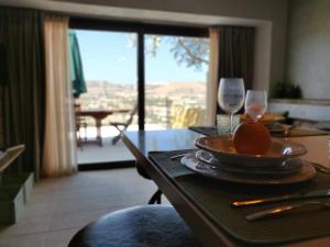 a table with a plate of food and wine glasses at The Loft Gozo in Xagħra