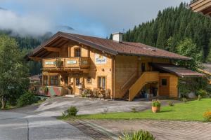 une grande maison en bois dans les montagnes dans l'établissement Landhaus Bergzeit, à Filzmoos