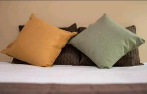 a bed with three pillows on top of it at Casa Mandala in Trelew