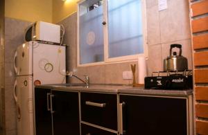 a small kitchen with a sink and a refrigerator at Casa Mandala in Trelew +8 photos
