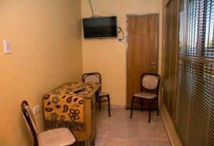 a room with a table and chairs and a television at Casa Mandala in Trelew
