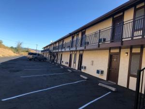a car parked in a parking lot next to a building at Golden Hills Motel in Tehachapi +2 photos