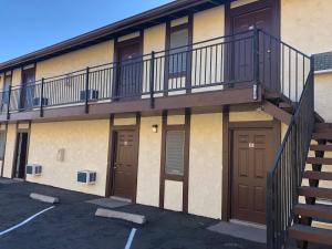 um edifício de apartamentos com uma varanda e duas portas em Golden Hills Motel em Tehachapi