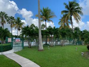 un parque con palmeras y una valla en Fairway Inn Florida City Homestead Everglades en Florida City