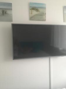 a flat screen tv on a white wall at Apartament DeLux in Rewal