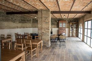 a room with wooden tables and chairs and windows at Casa Rural Julio Vegas in Santiago del Campo