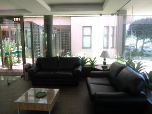 uma sala de estar com dois sofás e uma mesa de centro em Alto Estilo Barra Posto 8 no Rio de Janeiro